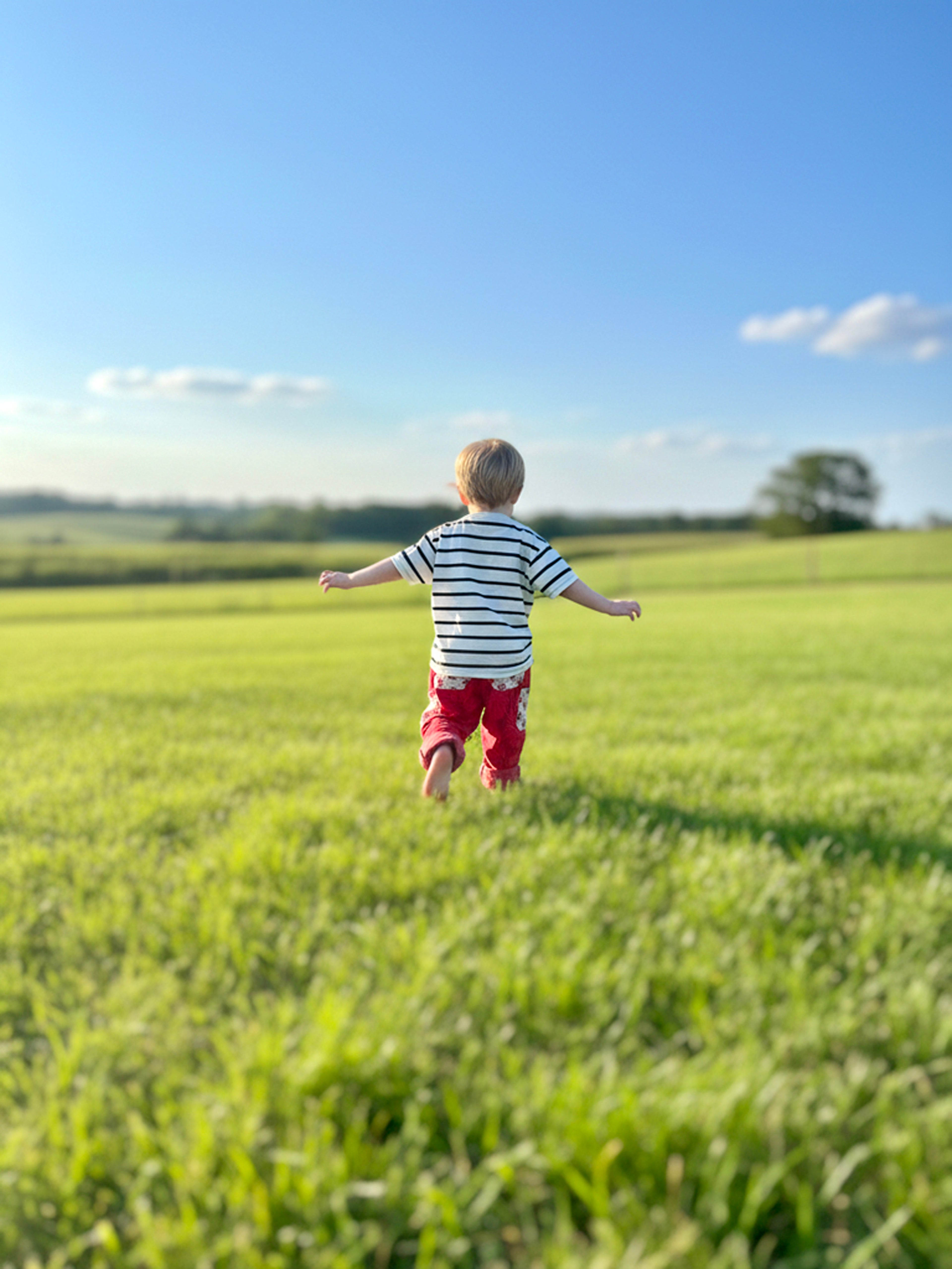 child running in a field wearing Honey Berry one of a kind kidswear